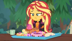 Size: 1920x1080 | Tagged: safe, derpibooru import, screencap, sunset shimmer, equestria girls, equestria girls series, wake up!, spoiler:choose your own ending (season 2), spoiler:eqg series (season 2), bread, candy, chocolate, clothes, croissant, cupcake, donut, eating, female, food, frosting, hot chocolate, jacket, junk food, mouthfull, mug, outdoors, pastries, pastry, solo, syrup, table, this will end in diabetes, tray, waffle, wake up!: pinkie pie