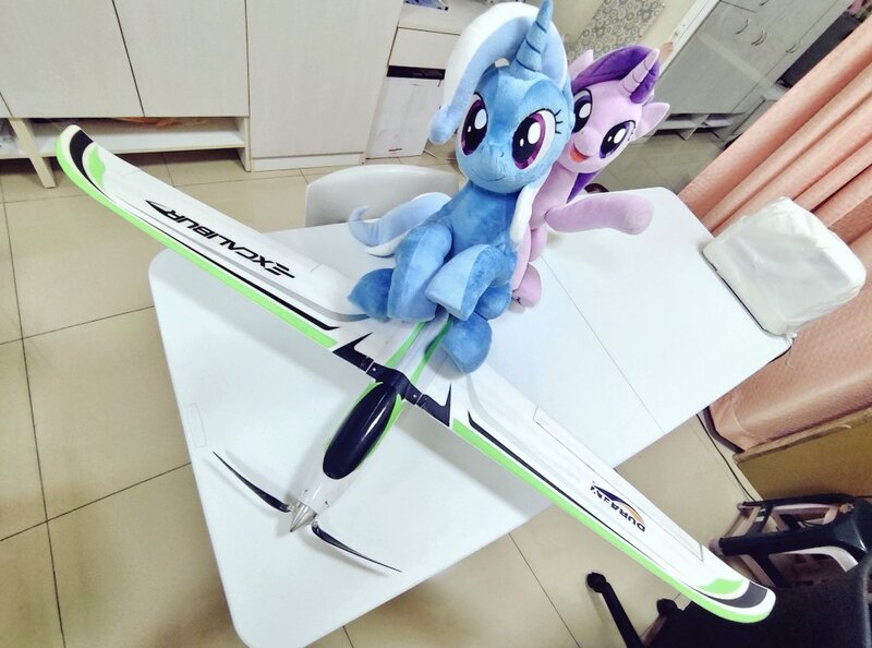Size: 1024x760 | Tagged: safe, artist:nekokevin, derpibooru import, starlight glimmer, trixie, pony, unicorn, series:nekokevin's glimmy, duo, female, irl, looking at you, mare, open mouth, photo, plane, plushie, raised hoof, rc plane, sitting, smiling, table, underhoof