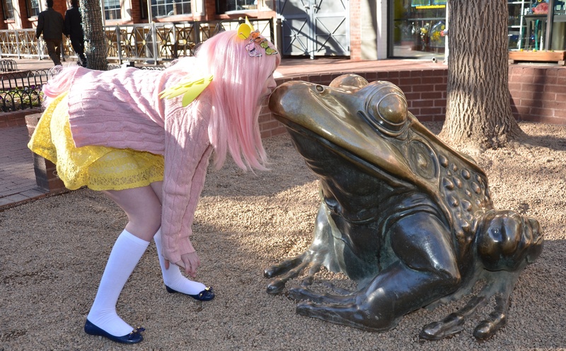 Size: 4072x2524 | Tagged: artist:lochlan o'neil, brick wall, clothes, cosplay, costume, craft, crouching, day, derpibooru import, dress, female, fluttershy, frog, hairpin, human, human female, irl, irl human, kissing, photo, railing, safe, sculpture, skirt, solo, statue, sweater, sweatershy, tail, touching face, tree