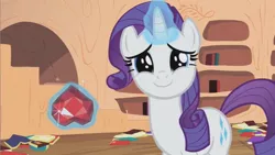 Size: 853x480 | Tagged: safe, derpibooru import, screencap, rarity, pony, unicorn, secret of my excess, cute, dilated pupils, female, fire ruby, golden oaks library, happy, looking at you, mare, raribetes, smiling, solo