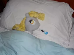 Size: 600x450 | Tagged: safe, artist:eratosofcyrene, derpibooru import, derpy hooves, pegasus, pony, bed, ear thermometer, female, irl, mare, photo, pillow, plushie, sick, solo