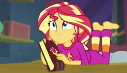 Size: 1251x720 | Tagged: safe, derpibooru import, screencap, sunset shimmer, equestria girls, barefoot, book, clothes, feet, female, image, jpeg, lying down, on stomach, pajamas, solo