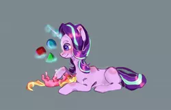 Size: 1030x664 | Tagged: safe, artist:lunar_cosmos, derpibooru import, luster dawn, starlight glimmer, pony, unicorn, blocks, cute, daaaaaaaaaaaw, female, filly, foal, glimmerbetes, glowing horn, gray background, horn, levitation, lusterbetes, lying down, magic, mama starlight, mother and child, mother and daughter, offspring, parent:starlight glimmer, parent:sunburst, parents:starburst, simple background, smiling, telekinesis