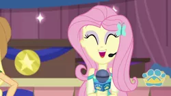 Size: 1280x720 | Tagged: safe, derpibooru import, screencap, applejack, fluttershy, best in show: the victory lap, equestria girls, equestria girls series, spoiler:eqg series (season 2), ^^, best in show logo, cute, eyes closed, hairpin, image, microphone, offscreen character, open mouth, png, shyabetes, smiling