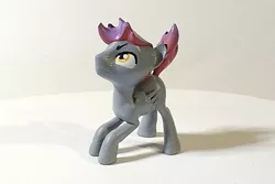 Size: 900x600 | Tagged: safe, artist:mraagh, derpibooru import, oc, oc:bordy, unofficial characters only, pegasus, pony, 3d, 3d print, 3d printed, eyebrows, eyes open, figurine, gray coat, image, jpeg, looking up, male, multicolor hair, photo, shadow, simple background, solo, squatting, stallion, yellow eyes