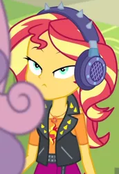 Size: 1920x2798 | Tagged: safe, derpibooru import, screencap, sunset shimmer, sweetie belle, equestria girls, equestria girls series, overpowered (equestria girls), clothes, cropped, cutie mark, cutie mark on clothes, female, geode of empathy, hallway, headphones, high res, image, jacket, jewelry, jpeg, leather, leather jacket, lidded eyes, lockers, magical geodes, necklace, solo focus