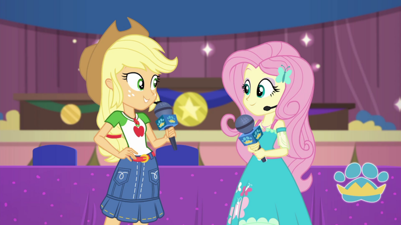Size: 1000x563 | Tagged: safe, derpibooru import, screencap, applejack, fluttershy, best in show: the victory lap, equestria girls, equestria girls series, spoiler:eqg series (season 2), applejack's hat, clothes, cowboy hat, dress, geode of fauna, geode of super strength, hand on hip, hat, image, looking at each other, magical geodes, microphone, png, skirt, smiling