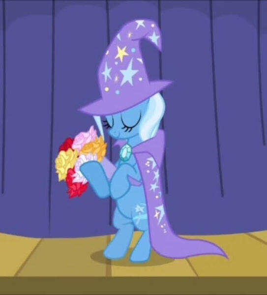 Size: 652x720 | Tagged: safe, derpibooru import, screencap, trixie, pony, unicorn, boast busters, bipedal, bouquet, cape, clothes, cropped, curtains, eyes closed, flower, hat, image, jpeg, smiling, stage, stars, trixie's cape, trixie's hat