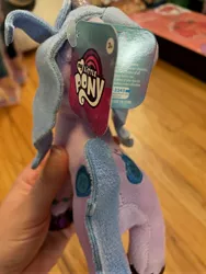 Size: 3024x4032 | Tagged: safe, derpibooru import, izzy moonbow, pony, unicorn, my little pony: a new generation, both cutie marks, facing away, female, g5, image, irl, jpeg, mare, my little pony logo, photo, plushie, toy