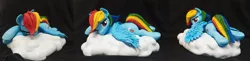 Size: 2277x552 | Tagged: safe, artist:vita96, derpibooru import, rainbow dash, pegasus, pony, cloud, craft, female, frog (hoof), image, irl, jpeg, looking at you, lying down, mare, on a cloud, one eye closed, photo, polymer clay, prone, sculpture, solo, underhoof