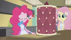 Size: 3410x1920 | Tagged: safe, derpibooru import, screencap, fluttershy, pinkie pie, acadeca, equestria girls, friendship games, apron, cake, clothes, female, food, hairpin, image, jpeg, smiling, tanktop
