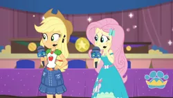Size: 3410x1920 | Tagged: safe, derpibooru import, screencap, applejack, fluttershy, best in show: the victory lap, equestria girls, equestria girls series, spoiler:eqg series (season 2), applejack's hat, belt, best in show logo, clothes, cowboy hat, cutie mark, cutie mark on clothes, denim skirt, female, geode of fauna, geode of super strength, hairpin, hand on hip, hat, image, jewelry, jpeg, magical geodes, microphone, necklace, skirt, smiling