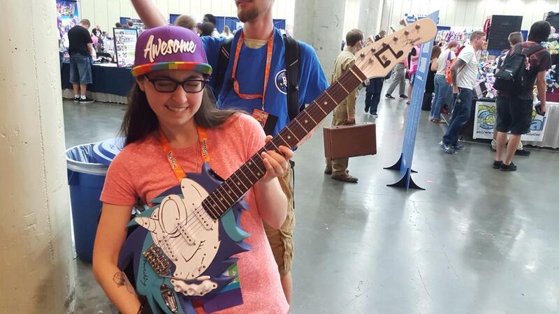 Size: 1024x576 | Tagged: safe, artist:nowacking, derpibooru import, vinyl scratch, human, bronycon, bronycon 2015, electric guitar, eyes closed, guitar, image, irl, irl human, jesse nowack, jpeg, musical instrument, photo