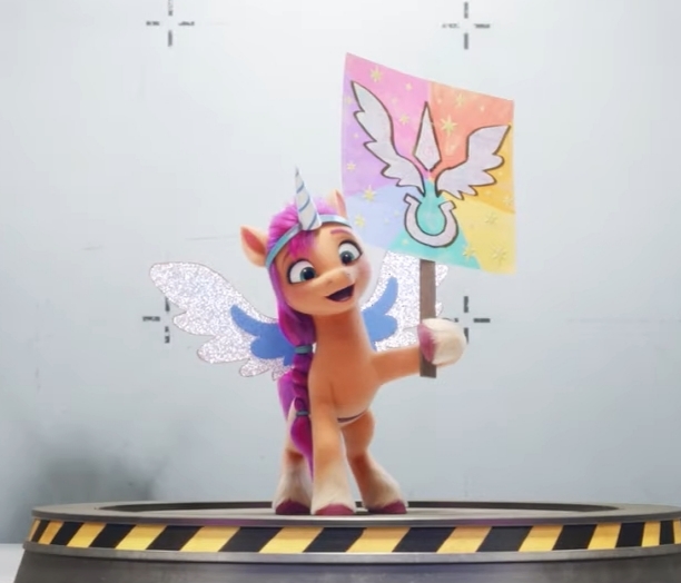 Size: 612x524 | Tagged: safe, derpibooru import, screencap, sunny starscout, g5, my little pony: a new generation, spoiler:g5, spoiler:my little pony: a new generation, alicorn costume, clothes, costume, fake horn, fake wings, image, jpeg, sign