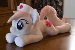 Size: 5184x3456 | Tagged: safe, artist:azgchip, derpibooru import, nurse redheart, earth pony, pony, cute, female, g4, hat, image, irl, lying down, mare, nurse hat, photo, plushie, png, pony plushie, prone, solo, table