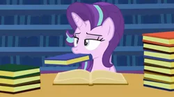 Size: 1438x804 | Tagged: safe, artist:agrol, derpibooru import, edit, editor:fluttershyisnot adoormat, starlight glimmer, unicorn, book, bookshelf, image, jpeg, mouth hold, nom, solo, starlight glimmer is not amused, unamused