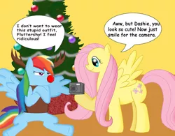 Size: 800x625 | Tagged: safe, derpibooru import, fluttershy, rainbow dash, pegasus, pony, animal costume, camera, christmas, christmas tree, clothes, costume, crossed arms, crossed hooves, duo, duo female, female, frown, holiday, image, jpeg, mare, rainbow dash always dresses in style, rainbow dash is not amused, red nose, reindeer costume, reindeer dash, rudolph dash, sitting, smiling, speech bubble, spread wings, talking, tree, unamused, wings