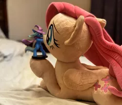 Size: 1703x1463 | Tagged: safe, derpibooru import, photographer:xbi, fluttershy, trixie, pegasus, pony, bed, cape, clothes, digital art, figurine, hat, image, irl, jpeg, mixed media, on bed, photo, plushie, trixie's cape, trixie's hat, welovefine