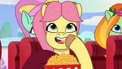 Size: 3072x1727 | Tagged: safe, derpibooru import, screencap, posey (g5), unnamed character, earth pony, pony, g5, my little pony: tell your tale, spoiler:g5, spoiler:my little pony: tell your tale, spoiler:tyts01e69, eating, equestria's got talent, female, food, image, jpeg, mare, open mouth, open smile, popcorn, smiling, trio, trio female