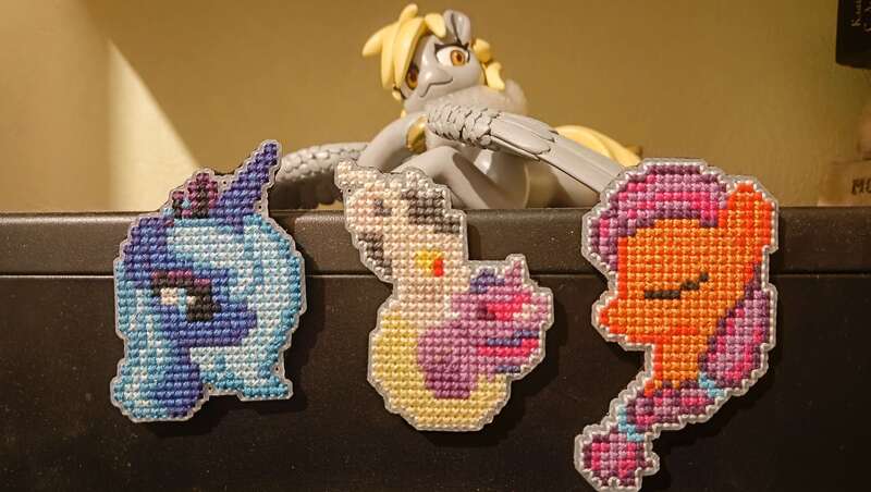 Size: 4080x2304 | Tagged: safe, artist:kujivunia, derpibooru import, derpy hooves, discord, princess luna, sunny starscout, twilight sparkle, g5, craft, cross stitch, eyes closed, figurine, fridge magnet, hug, image, jpeg, kissing, looking at each other, looking at someone, magnet icon, statuette