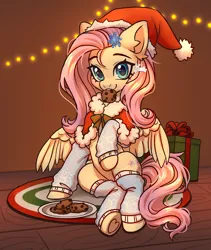Size: 3800x4500 | Tagged: safe, artist:konejo, derpibooru import, fluttershy, pegasus, pony, absurd resolution, christmas, christmas lights, clothes, commission, cookie, cute, daaaaaaaaaaaw, ear fluff, eyebrows, female, food, g4, hair accessory, hat, holiday, image, indoors, leg warmers, looking at you, mare, mouth hold, partially open wings, pelerine, png, present, raised hoof, santa hat, shyabetes, sitting, smiling, smiling at you, solo, underhoof, wings