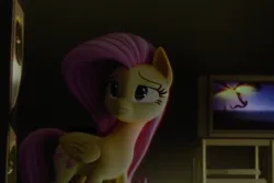 Size: 768x512 | Tagged: safe, derpibooru import, machine learning generated, fluttershy, pegasus, pony, 3d, 3d model, black eye, blurry background, cutie mark, eyes open, fake, image, movie, pink hair, pink mane, png, realistic, room, sad, solo, television, vhs, witch