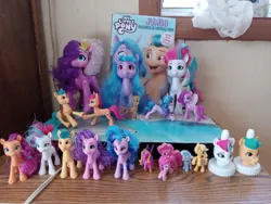 Size: 960x720 | Tagged: safe, derpibooru import, applejack, hitch trailblazer, izzy moonbow, pinkie pie, pipp petals, princess cadance, silver spoon, sunny starscout, zipp storm, alicorn, earth pony, pegasus, pony, unicorn, collection, coloring book, female, g5, good2grow, image, irl, jpeg, photo, pipp is tall, royal sisters (g5), siblings, sisters, toy