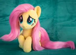 Size: 1984x1446 | Tagged: safe, artist:buttercupbabyppg, derpibooru import, fluttershy, pegasus, pony, female, folded wings, image, irl, jpeg, lying down, mare, photo, plushie, prone, smiling, solo, wings