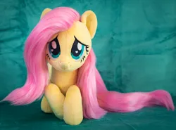 Size: 1852x1371 | Tagged: safe, artist:buttercupbabyppg, derpibooru import, fluttershy, pegasus, pony, female, folded wings, image, irl, jpeg, lying down, mare, photo, plushie, prone, smiling, solo, wings