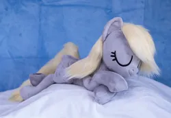 Size: 1382x950 | Tagged: safe, artist:buttercupbabyppg, derpibooru import, derpy hooves, pegasus, pony, eyes closed, female, folded wings, happy, image, irl, jpeg, lying down, mare, photo, plushie, prone, sleeping, wings