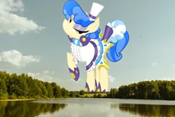 Size: 6000x4000 | Tagged: safe, artist:dashiesparkle, derpibooru import, edit, editor:jaredking779, sapphire shores, earth pony, pony, absurd resolution, clothes, female, giant pony, giantess, hat, highrise ponies, image, irl, jpeg, lake, looking at you, macro, mare, photo, ponies in real life, raised hoof, scenery, smiling, solo, tree, water