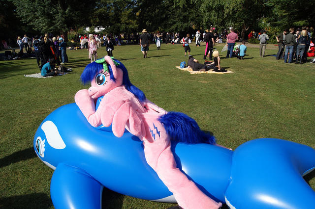 Size: 640x426 | Tagged: safe, artist:atalonthedeer, derpibooru import, firefly, human, whale, g1, 2012, connichi, fursuit, grass, grass field, image, inflatable, irl, irl human, jpeg, lying down, outdoors, photo, ponysuit, prone, solo focus