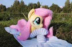 Size: 1915x1273 | Tagged: safe, artist:nakedskull, derpibooru import, fluttershy, pegasus, pony, g4, clothes, fluttershy plushie, forelegs crossed, image, irl, lying down, nature, outdoors, photo, plushie, png, prone, socks, solo, striped socks, water