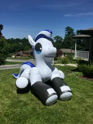 Size: 2448x3264 | Tagged: safe, artist:tbolt, derpibooru import, oc, oc:thistle down, unofficial characters only, earth pony, inflatable pony, pony, earth pony oc, female, female oc, grass, house, houses, image, inflatable, inflation valve, irl, jpeg, lying down, mare, mare oc, on grass, opaque inflatable, outdoors, photo, solo, summer, two toned mane, white coat