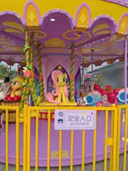 Size: 4124x5499 | Tagged: safe, derpibooru import, official, applejack, fluttershy, pinkie pie, spike, pony, g4, apple, carousel, chinese text, food, front view, image, irl, jpeg, looking at you, moon runes, open mouth, party cannon, photo, sitting, spread wings, statue, swing, text, wings