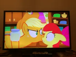 Size: 3264x2448 | Tagged: safe, derpibooru import, apple bloom, applejack, earth pony, pony, the perfect pear, angry, angry kiss, female, filly, foal, g4, image, jpeg, kissing, mare, out of context, pear jam, photo, picture of a screen