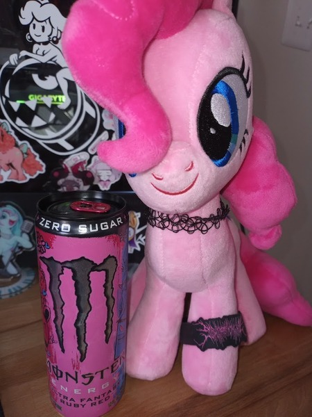 Size: 712x949 | Tagged: safe, artist:casettepony, derpibooru import, pinkie pie, earth pony, original species, plush pony, pony, blue eyes, bracelet, choker, drink, energy drink, front facing, front view, hair over one eye, image, irl, jewelry, jpeg, light switch, monster energy, photo, pink coat, pink mane, plushie, solo, sticker, tumblr, wooden table
