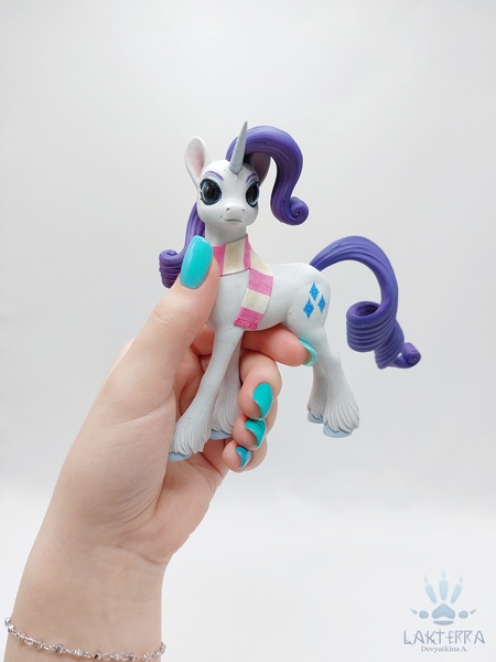 Size: 1620x2160 | Tagged: safe, alternate angle, alternate version, artist:lakterra, derpibooru import, rarity, human, pony, unicorn, clothes, craft, female, figurine, g4, hand, holding a pony, horn, image, irl, jpeg, mare, photo, polymer clay, scarf, signature, simple background, striped scarf, tail, unshorn fetlocks, white background