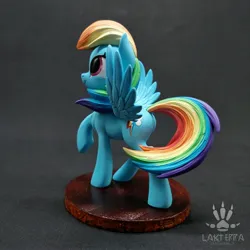 Size: 2560x2560 | Tagged: safe, alternate angle, alternate version, artist:lakterra, derpibooru import, rainbow dash, pegasus, pony, butt, craft, female, figurine, g4, image, irl, jpeg, looking up, mare, photo, plot, polymer clay, raised hoof, signature, smiling, solo, spread wings, stand, tail, three quarter view, wings