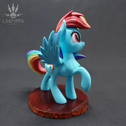 Size: 2560x2560 | Tagged: safe, alternate angle, alternate version, artist:lakterra, derpibooru import, rainbow dash, pegasus, pony, craft, female, figurine, g4, image, irl, jpeg, looking up, mare, photo, polymer clay, raised hoof, side view, signature, smiling, solo, spread wings, stand, tail, wings