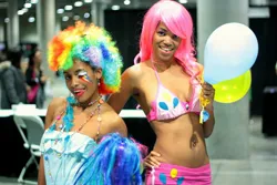 Size: 2800x1867 | Tagged: safe, artist:xaleux, derpibooru import, pinkie pie, rainbow dash, human, african american, balloon, belly, belly button, belly piercing, bellyring, bikini, bikini top, breasts, clothes, cosplay, costume, dark skin, duo, duo female, female, hand on hip, image, irl, irl human, jpeg, looking at you, photo, piercing, pinkie pie's cutie mark, rainbow wig, rave, shorts, smiling, smiling at you, standing, swimsuit, wig, woman