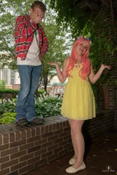 Size: 684x1024 | Tagged: safe, derpibooru import, big macintosh, fluttershy, human, 2015, brick wall, clothes, cosplay, costume, cutie mark, cutie mark on clothes, denim, dress, duo, duo male and female, facepalm, female, floral head wreath, flower, fluttermac, holding hands, image, irl, jeans, jpeg, male, outdoors, pants, photo, plaid shirt, shipping, shirt, shoes, shrug, straight, t-shirt, tree, wig, wings