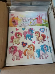 Size: 3000x4000 | Tagged: safe, derpibooru import, izzy moonbow, pinkie pie, pony, unicorn, g5, box, castle, dollar tree, female, heart, image, irl, jpeg, male, not izzy moonbow, not pinkie pie, photo, tattoo