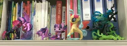 Size: 3544x1307 | Tagged: safe, derpibooru import, photographer:jess181307, queen chrysalis, twilight sparkle, twilight sparkle (alicorn), alicorn, changeling, changeling queen, book, bookshelf, chinese text, female, funko, funko pop!, image, irl, jpeg, moon runes, photo, toy